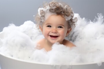 Baby taking a bath with foam and soap bubbles.