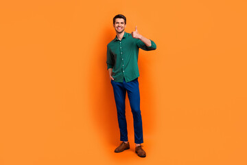 Full length photo of excited confident man dressed green shirt showing thumb up isolated orange color background