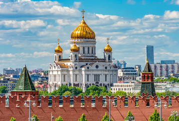 Fototapeta na wymiar Wall and towers of Moscow Kremlin with Cathedral of Christ the Savior (Khram Khrista Spasitelya) at background, Russia