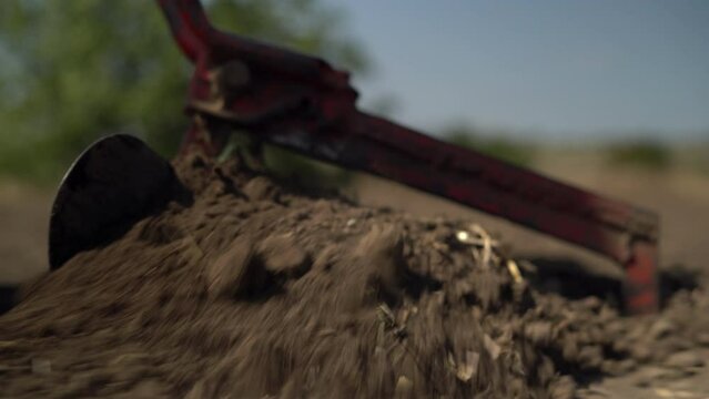 Farmer using manual plow and plowing soil in field