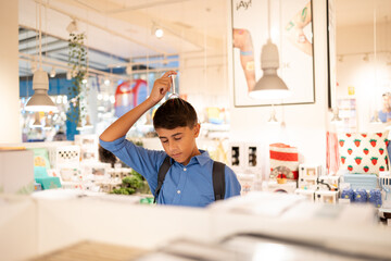 Curious kid testing a soothing head massager while shopping