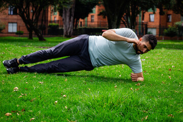 young man doing abdominal exercise in a park in the city