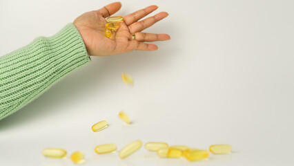 Dropping Omega-3-rich wild salmon and fish oil capsules against a gentle off-white background.