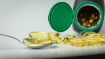 Omega-3-rich wild salmon and fish oil capsules spilling out from the bottle, showcased against a gentle off-white background.