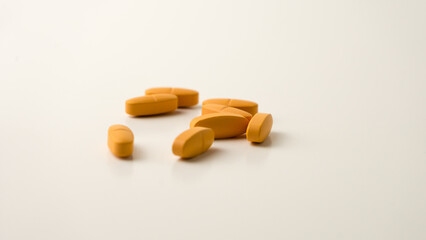 Multivitamin supplement pills set against a neutral off-white backdrop.