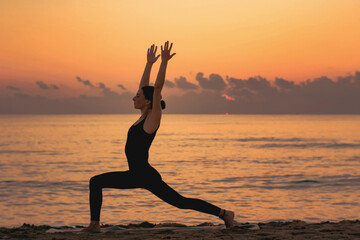 young girl practicing yoga at the beach at sunrise
