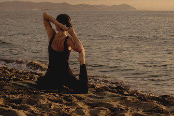  young girl practicing yoga at the beach at sunrise