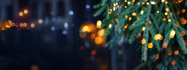 Christmas tree with garland lights. Evening city with blurred background and bright lights - 663992580