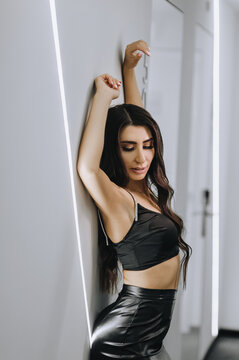 Photography, close-up portrait of a beautiful sexy young girl, brunette woman, Armenian woman in black lingerie, leather dress indoors in a hotel.