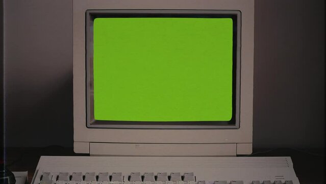 Vintage Computer Green Screen Glitch Old Desktop PC Zoom In. Retro desktop computer with green screen glitch, for replacement, zoom in. VHS Film texture