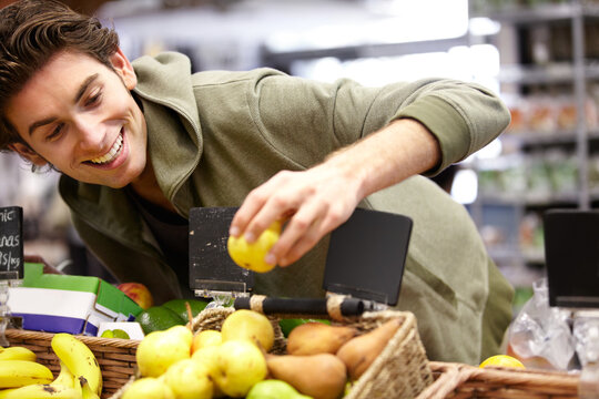 Man, smile and fruit in grocery store for health diet, nutrition or shopping sale product. Male person, happy customer and apple choice in supermarket for organic vegan, quality price or fibre food