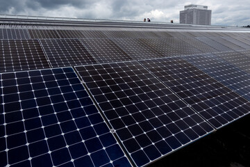 blauen Photovoltaik-Solarmodule auf dem Dach eines öffentlichen Gebäudes

