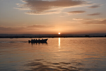 A boat floating on a sunset on a Sicilian coast from Italy 