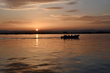A boat floating on a sunset on a Sicilian coast from Italy 