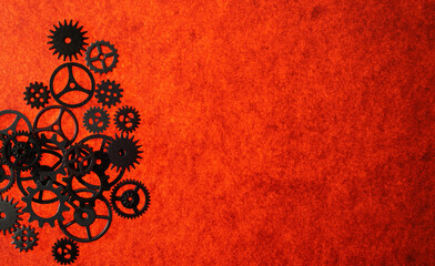 Assorted mechanical gears on orange textured  background with copy space