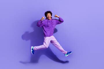 Full size photo of ecstatic overjoyed person dressed violet hoodie pants win lottery scream yes isolated on purple color background