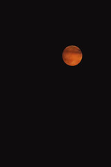 orange moon in the dark sky at night