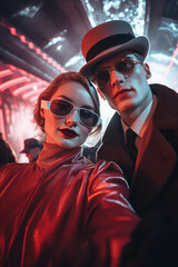 self portrait of a man in a red hood and a glamour girlfirend, elegant dressed looking at the camera