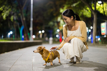 Woman go for a walk with her dog at night