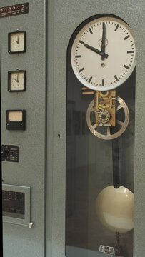 Old pendulum clock, amperage meter, vintage ammeter, instrument to measure time and electricity in industrial setting, Vertical video 4k