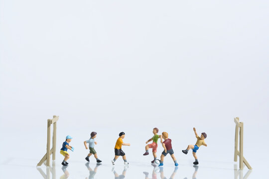 Children playing football, miniature figures scene, white background, copy space