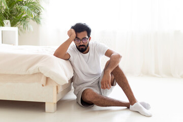 Melancholy Concept. Thoughtful Upset Indian Man Sitting On Floor In Bedroom