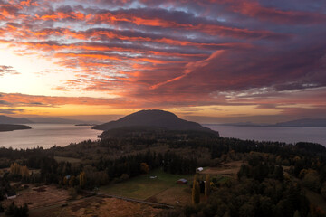 Dramatic aerial sunrise view over Lummi Island in the Salish Sea area of Washington state. Looking south over Lummi Mountain the clouds are beautifully framing the island on this autumn morning.