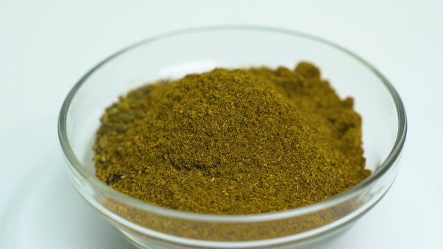 A transparent plate with a mixture of seasonings rotates on the turntable. Close-up. View from above