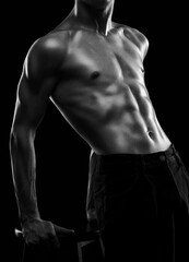 Fototapeta premium Silhouette of a slender muscular man doing sports in the gym. Sports and healthy lifestyle.