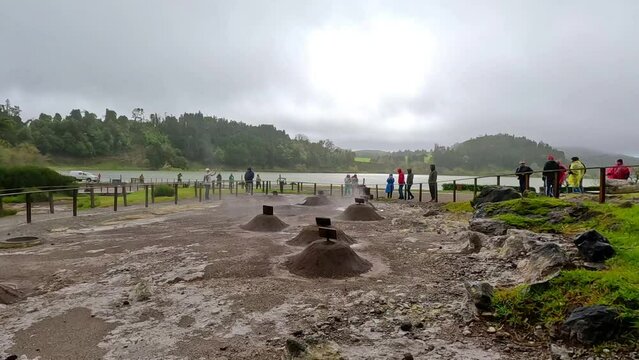 Furnas, Azores; 27th March 2023: Geysers where the stew (Cozinhou) is cooked in the ground in the hot water inside the geysers in a hole, and lots of fumes, while lots of tourists see the scene
