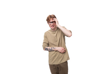 Fototapeta premium surprised young European guy with red hair dressed in a fashionable brown shirt and trousers on a white background. people lifestyle concept
