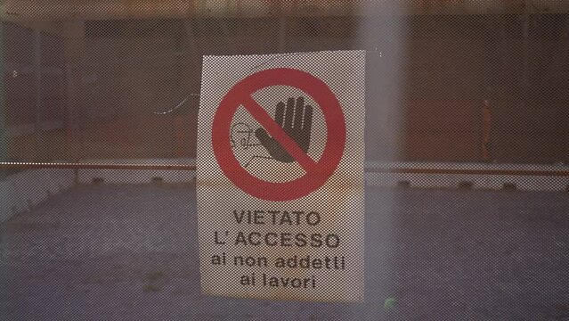 Closeup of prohibition sign on wall of building during renovation work by Roman Colosseum amphitheater, slow motion. Concept of restoration and reconstruction of historic cultural landmarks.