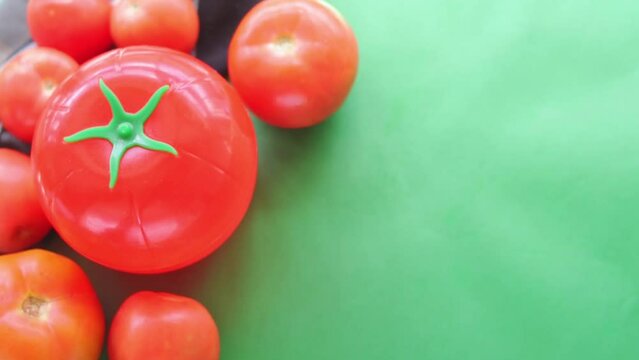 Hand taking tomato pot on green background 