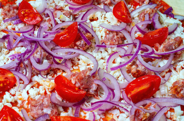 ingredients of uncooked pizza with meat, tomatoes, blue onions, close-up