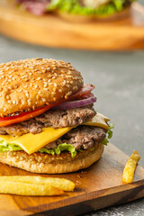 Homemade burger with two meats, cheese, lettuce, tomato and onion