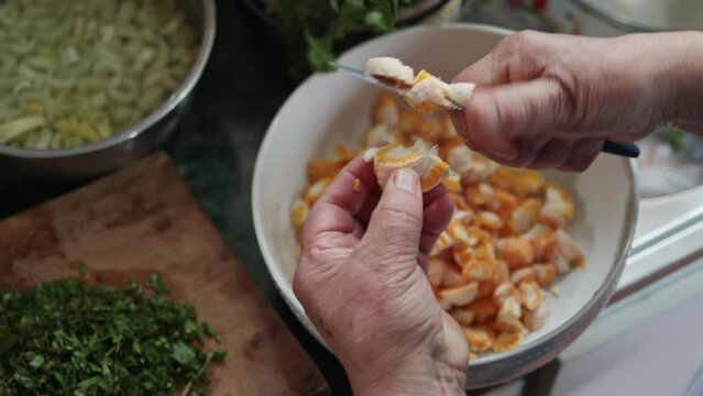 Top view of unrecognizable woman preparing chilean diguenes salad, cyttaria espinosae, edible mushroom in southern Chile