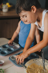 Two children preparing the figurines on the table for muffins. The preparation of the dessert.