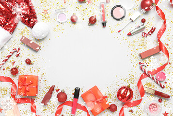 Frame made of makeup products with Christmas decor and gifts on light background. Banner for design