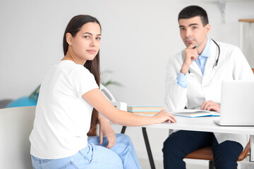 Young woman with bad posture visiting doctor in clinic