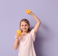 Cute little girl with glass of juice and orange on lilac background