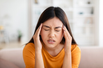 Asian woman suffer from headache, home interior