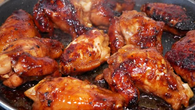 Marinated chicken wings are fried in a frying pan