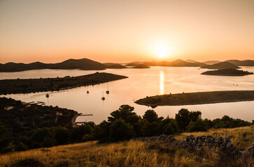 Beautiful sunset over the famous Kornati national park in Croatia, Europe, view from the top of the Zut island, sailboats on the sea