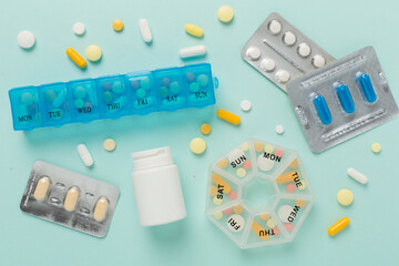 Daily pill box with medications on color background, top view