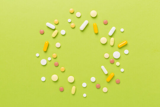 Different pills on color background, top view