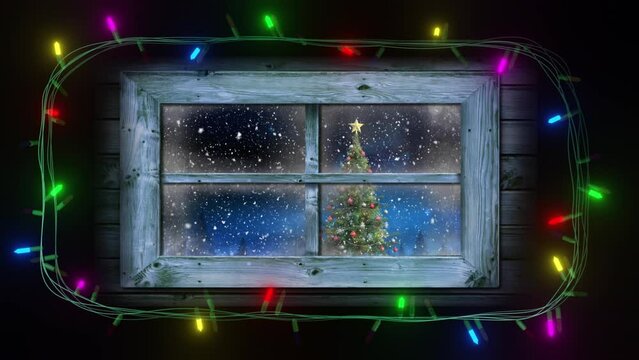 Frame of coloured string lights flashing around window with view of christmas tree and falling snow