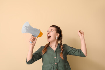 Young woman shouting into megaphone on beige background