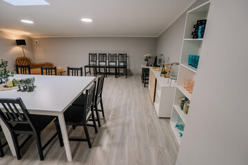 Cozy interior with stylish furniture and modern design. Empty stylish glasses on shelf unit near wall