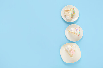 Plates with pieces of yummy Birthday cake on blue background