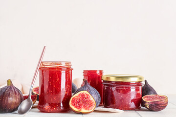 Jars of sweet fig jam on white tile table